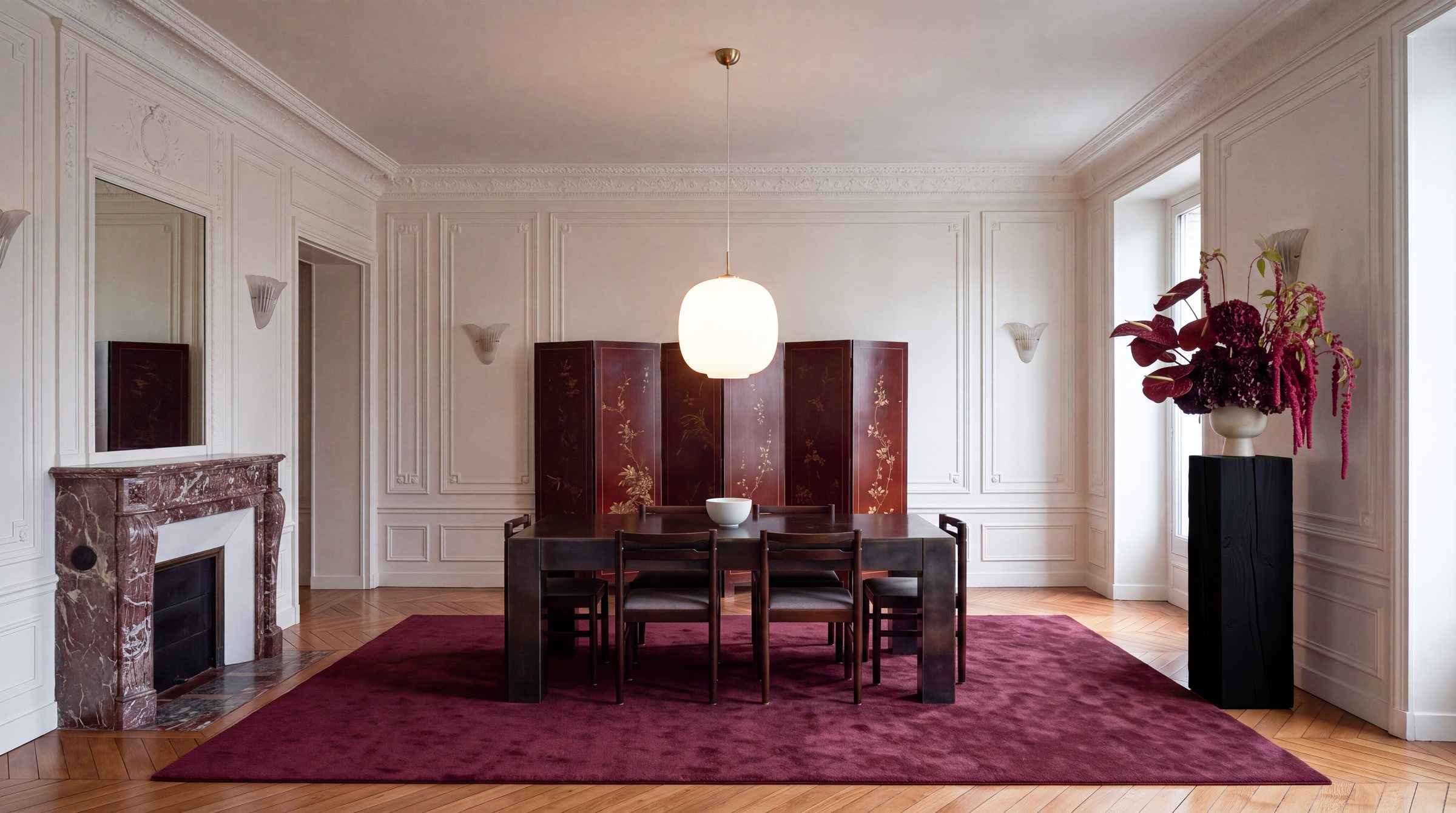 Black pedestal with a red floral arrangement in a Parisian dining room