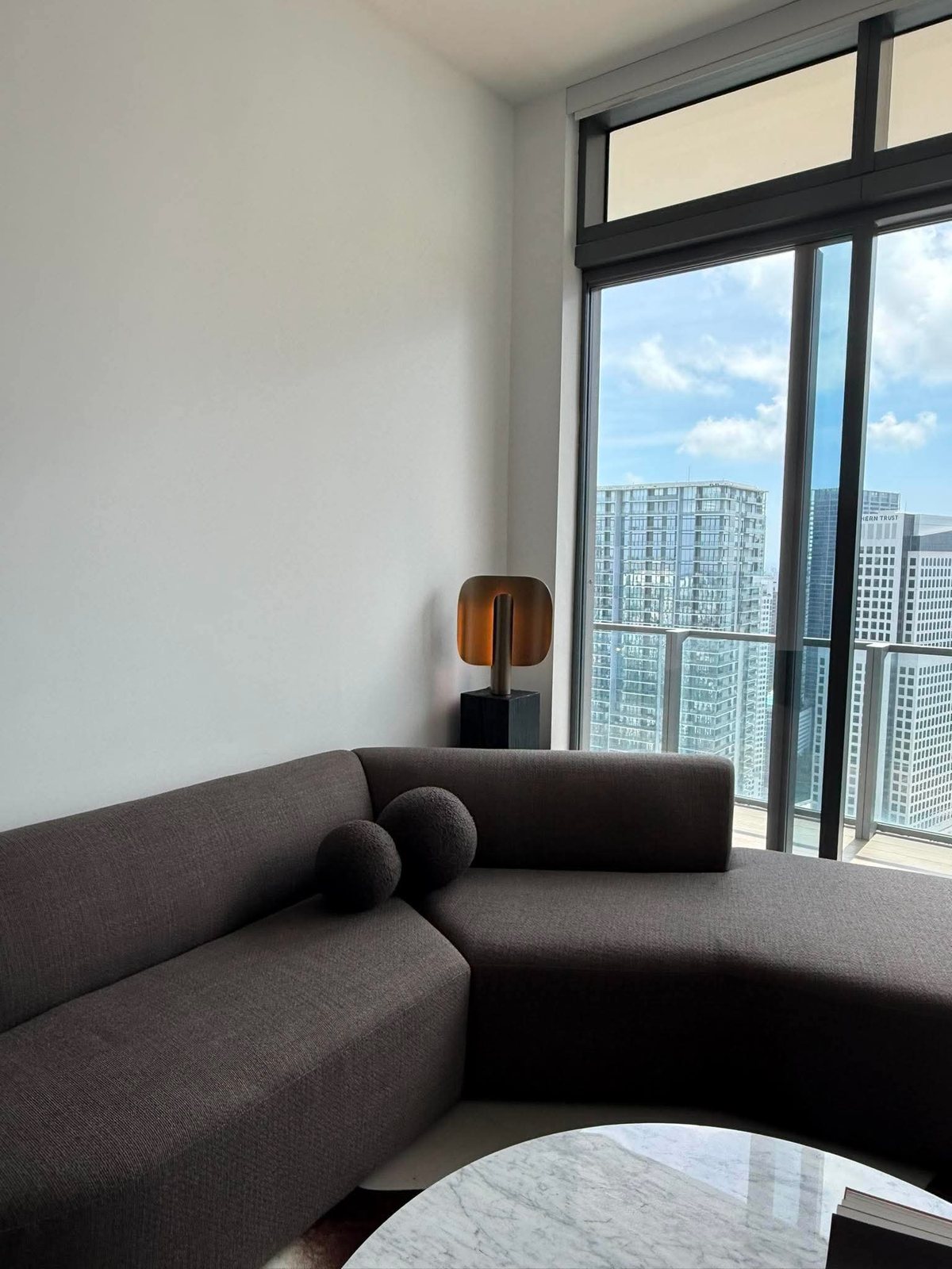 Small black pedestal holding a lamp in a living room with city views